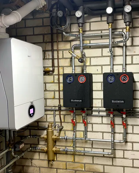 Cv-ketel met verdelers en leidingwerk in een technische ruimte